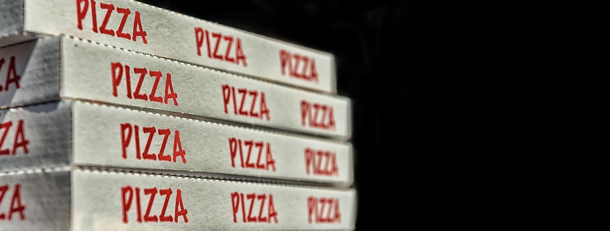 Large stack of pizza boxes. Isolated over black.